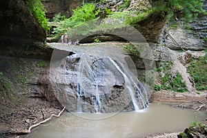 Tourists rest on the top of a waterfall