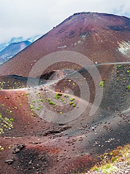 Tourists on ridge between big craters on Etna