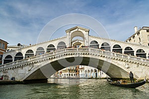 Tourists riding on gondola close to Ponte Rialto bridge on Canal Grande in Venice, Italy