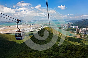 Tourists riding in gondolas of Ngong Ping Cable Car Skyrail over the mountainside on Lantau Island