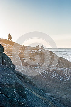 Tourists on a rocky shore, the island of Mageroya, Norway