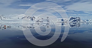 Tourists sails by boat on ocean bay at melting icebergs. Expedition on global warming