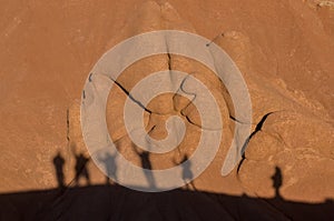 Tourists' shadows stretch across canyon rocks, a testament to adventurous spirits exploring the rugged beauty of