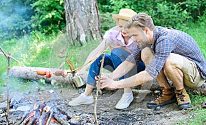 Tourists sit log near bonfire taking photo on smartphone. Couple on vacation capture moment. Couple near bonfire enjoy