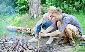 Tourists sit log near bonfire taking photo on smartphone. Couple on vacation capture moment. Man taking photo of bonfire