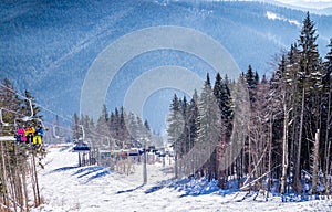 Tourists on the ski slopes and a modern chair lift. Holiday in the ski resort Bukovel