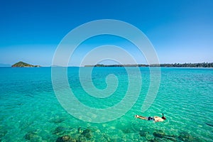 Tourists snorkel in crystal turquoise water near tropical resort in Phuket, Thailand. Summer, Vacation, Travel and Holiday concept