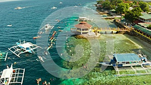 Tourists snorkeling in coral reef, Moalboal, Philippines