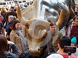 Tourists surrounding Wall Street Charging Bull Statue in Manhattan Financial District