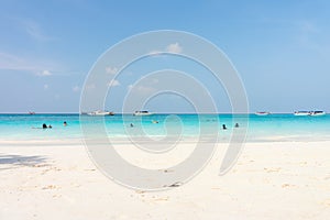 Tourists are swimming in the sea near the beach of Tachai island.