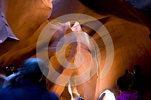 Tourists take pictures of the unique natural diverse sand labyrinths of the lower Antelope Canyon