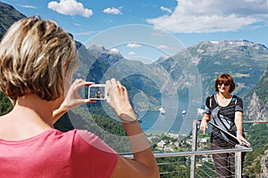 Tourists taking photo against Geirangerfjord photo