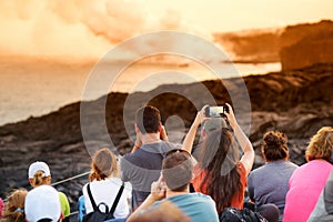 Tourists taking photos at Kalapana lava viewing area. Lava pouring into the ocean creating a huge poisonous plume of smoke at Hawa