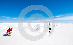 Tourists taking photos at sault banks in Salar de Uyuni