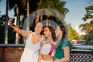 Tourists taking a selfie in one of the bridges along the Cali River Boulevard with La Ermita church on background in the city of photo