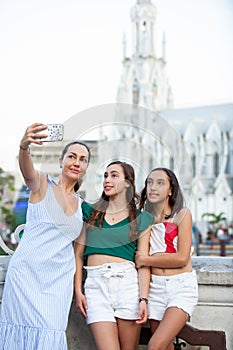 Tourists taking a selfie at the Ortiz Bridge with La Ermita church on background in the city of Cali in Colombia photo
