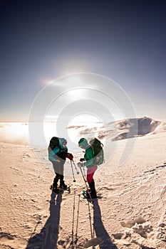 Tourists travel together in the mountains in winter. two girls snow-capped mountains