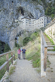 Tourists on a trek at Predjama Castle in Slovenia   Predjama Castle Predjama Slovenia