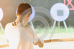 Tourists try to use a bow and arrow and shoot at a target