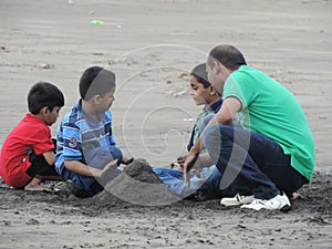 Tourists trying to build castle at Dandi Beach at dawn - Gujarat tourism - India beach holiday - Historical