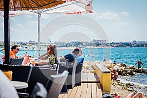 Tourists and various guests sitting at the bar by the sea and enjoy the sun in Zadar