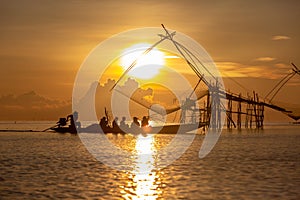 Tourists visit Chinese fish nets during sunrise