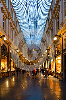 Tourists visit famous Royal Galleries of Saint Hubert in evening, Brussels, Belgium