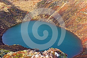 Tourists visit a volcanic crater lake in Iceland.