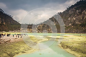 Tourists at the volcanic sulphur crater lake of Kawah Putih, Indonesia photo