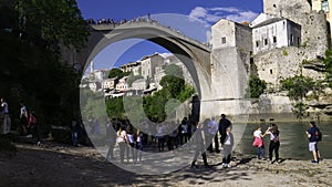 Tourists are waiting for a Bosnian diver to jump into the river Neretva. Mostar, Bosnia and Herzegovina, April 2019