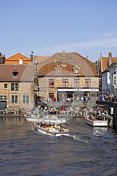 Tourists waiting in port at Rosary Quay for Boat trip for a water channel cruise, Bruges, Belgium