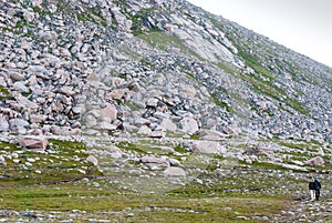 Tourists walk along the rocky slope, island of Mageroya, Norway