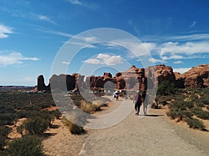 Tourists walking along path at Arches National Park