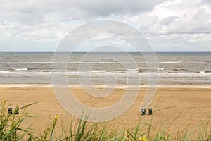 Tourists are walking along the sea line. Zandvoort is a main sea resort and touristic center.