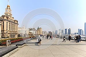 Tourists walking in the Bund, the most scenic spot in Shanghai. On background the most famous Chinese skyscrapers