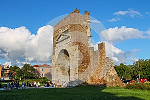 Tourists walking near the ancient arch of Augustus in Rimini, Italy