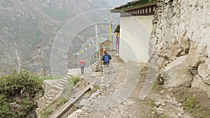 Tourists walking in nepalese village Prok, trek around mountain Manaslu, Nepal.