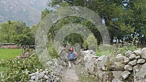 Tourists walking in nepalese village Prok, trek around mountain Manaslu, Nepal.