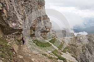 Tourists walking on a trail in mountains in a foggy day, Lagazuoi, Italian Alps