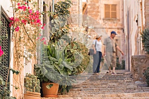 Tourists walking on typical mediterranean street in small town