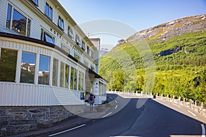 A tourists walks past the famous Hotel Utsikten, The View, overlooking the Geiranger Fjord, located on a curvy mountain road