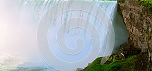 Tourists watching and exploring the bottom grounds of Niagara Falls giant water flow spectacular view