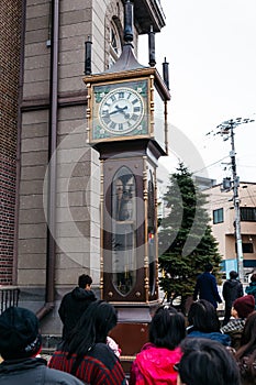 Tourists are watching Otaru steam clock and waiting for ring in Hokkaido, Japan