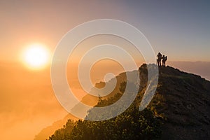 Tourists watching the sunrise at the top of the mountain