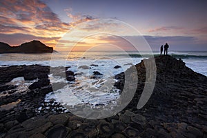 Tourists watching a sunset at the Giant's Causeway