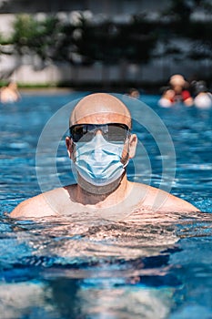 Tourists wear the protective mask in the pool to protect themselves from the coronavirus