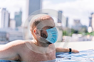 Tourists wear the protective mask in the pool to protect themselves from the coronavirus