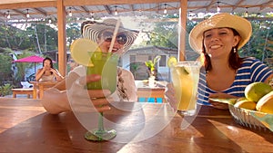 Tourists Women Claiming Drinks At A Lodge Bar In The Ecuadorian Amazon