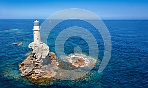 The Tourlitis lighthouse on a steep rock in calm, blue sea