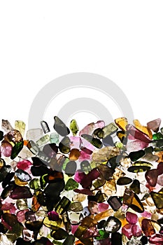 Tourmaline heap stones texture on half white light isolated background. Place for text